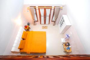 an overhead view of a living room with a yellow couch at Livio Homestay in Andalas +26 photos