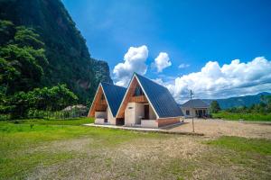 a house with a metal roof on a field at Livio Homestay in Andalas