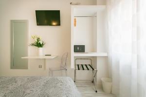 1 dormitorio con 1 cama, 1 silla y TV en Hostal Met Madrid en Madrid