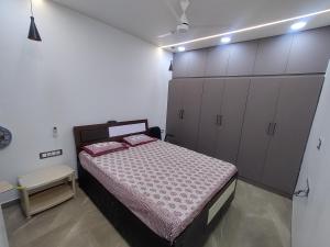 a bedroom with a bed and some cabinets at Om Niwas in Bhuj