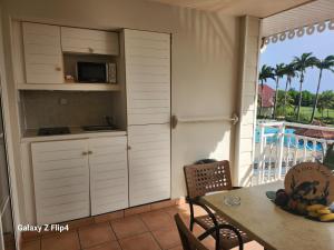 una cucina con tavolo e forno a microonde di Ti coco luce studio à Sainte Luce dans village de vacances a Sainte-Luce