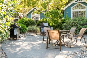 a patio with chairs and a table and a grill at RiverPointe Napa Valley Resort in Napa