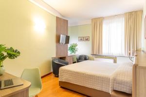 A bed or beds in a room at Hotel Ziò Imola