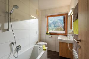 un bagno con vasca, WC e lavandino di Klausnerhof a Aschau