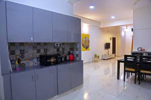 ハイデラバードにあるVeetil -3BHK AC, Kukatpally, Hyderabadの白いキャビネット付きのキッチン、ダイニングルーム
