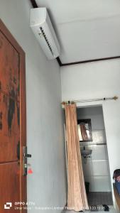 Cette chambre dispose d'un ventilateur de plafond et d'un rideau de douche. dans l'établissement Nadil Homestay, à Kuta Lombok