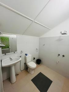 a bathroom with a white toilet and a sink at Avalon in Weligama +182 photos