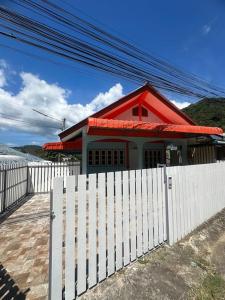 a house with a white fence and a red roof at P&I Group Home 4 Karon beach in Karon Beach