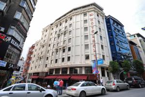 um grande edifício branco numa rua da cidade com carros em Delta Hotel Istanbul em Istambul