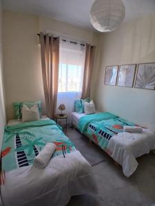 a bedroom with two beds and a window at Appartement Cosy et Familial in Safi