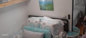 a room with two beds and a chair and a picture at Sugar Cakes Tiny House in Governorʼs Harbour