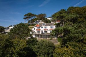a large white house on top of a hill at The Wood in Salcombe