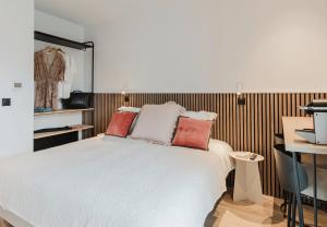 a bedroom with a bed with red pillows on it at Appart Hotel Neostelia in Annecy