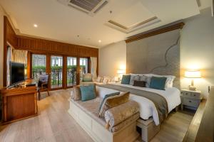 ein großes Schlafzimmer mit einem großen Bett und einem TV in der Unterkunft Maikhao Dream Villa Resort and Spa, Maikhao Phuket in Mai Khao Beach + 75 Fotos