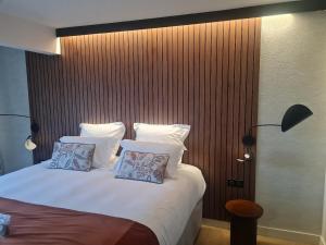 a bedroom with a bed with white sheets and pillows at Hôtel Breizh Du Golfe in Arzon