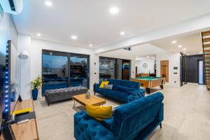 a living room with blue couches and a pool table at Luxury Villa Royal Hill with 34 m2 pool in Maslenica