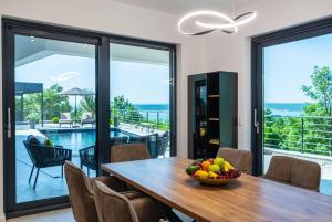 a dining room with a table with a bowl of fruit at Luxury Villa Royal Hill with 34 m2 pool in Maslenica