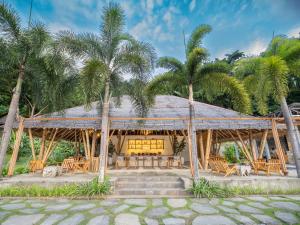 a pavilion with tables and palm trees at D'Lagoon Dive Resort in Bitung