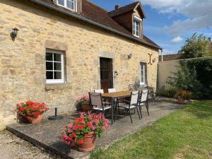 a table and chairs in front of a stone house at La Pommeraie in Fyé