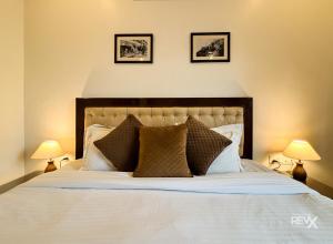 a bedroom with a white bed with two lamps at Hotel Sunny Cot - Free Mall Shuttle and Parking in Mussoorie