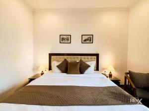 a bedroom with a large bed with two lamps at Hotel Sunny Cot - Free Mall Shuttle and Parking in Mussoorie