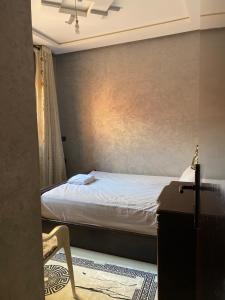 a bedroom with a bed and a table and a chair at The Caring Corner in Agadir