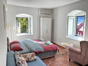 a bedroom with a bed and a couch and two windows at Villa Kamena in Kotor +82 photos