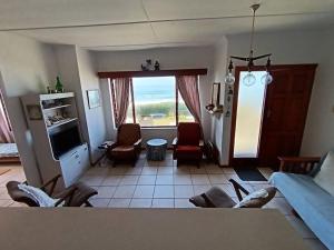 a living room with a couch and chairs and a window at Family beachfront cottage in Tergniet