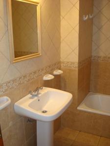 a bathroom with a sink and a mirror and a tub at Hosteria Miyazato Inn in El Calafate