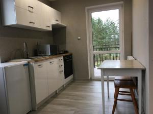 a small kitchen with a table and a window at Leśne Zacisze in Augustów