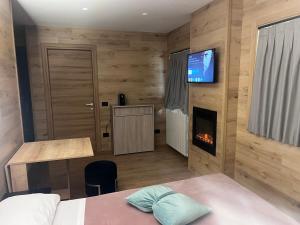 a bedroom with a bed and a tv and a fireplace at Anemone Bianco Suite Rooms in Passo del Tonale