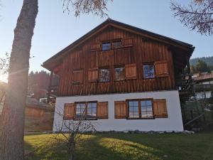 布赖尔Casa Seglias的一座有窗户和一棵树的大木屋