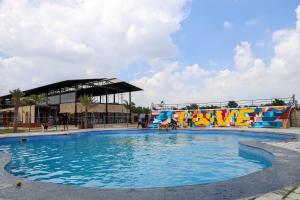a large swimming pool with people in the water at Therpup Resort in Bangalore