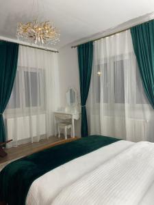 1 dormitorio con 1 cama grande y cortinas verdes en Căsuța bunicii, en Tureni 26 fotos más
