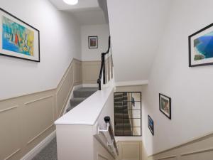 a staircase in a house with art on the walls at Demelza in St Austell +3 photos