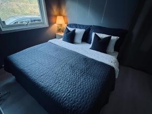 a bedroom with a large bed with blue sheets and pillows at Panorama view! Modern,Balcony/parking in Bodø
