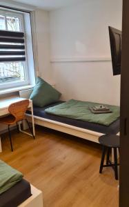 a room with a bed and a desk and a window at Wohnung Ilz - im Zentrum, Parkplatz, Küche, getrennte Betten in Passau