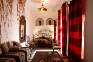 uma sala de estar com uma cama e um sofá em Riad Zara Maison d'Hôtes em Marraquexe