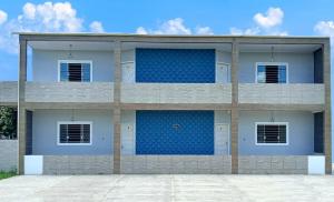 a blue and white building with four windows at Guará Apart 4 in Guaratuba