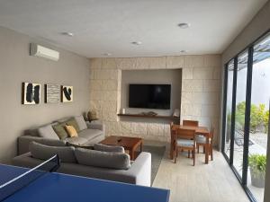 a living room with a couch and a tv at Deck 17 in Cozumel