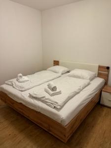 a bed with white sheets and towels on it at L&B Lake view modern apartment in Lipno nad Vltavou