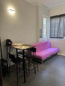 een woonkamer met een roze bank en een tafel bij Al 304 a San Giovanni in Rome