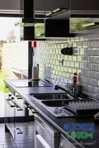 a kitchen with a sink and a counter top at Casa do Jardim in Santa Cruz da Graciosa