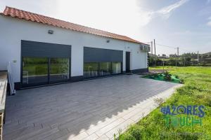 a house with a large patio in front of it at Casa do Jardim in Santa Cruz da Graciosa