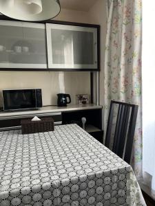a room with a table and a microwave and a kitchen at 小渓荘 in Tokyo