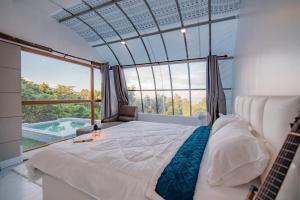 a bedroom with a large bed and a large window at เดอะ ม้ง โฮมสเตย์ The Hmong Home Stay Chiangmai in Ban Tai +106 photos