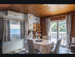 a dining room with a table and chairs and a window at Apartman Fortunal in Blato