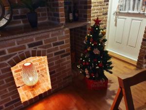 a christmas tree in a brick fireplace with a candle at Executive Home in Jeju in Jeju