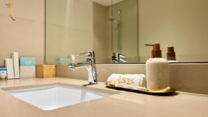 a bathroom sink with a towel and a faucet at 1BR Apartment in Yas Island with Private Balcony in Abu Dhabi