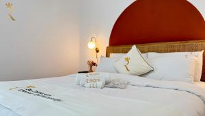 a white bed with a red headboard and white pillows at 1BR Apartment in Yas Island with Private Balcony in Abu Dhabi